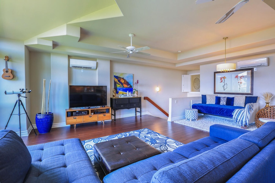 Spacious living area with multiple seating areas and a flat-screen TV.