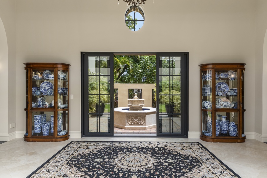 The foyer offering a view of the outdoor fountain and lush greenery.