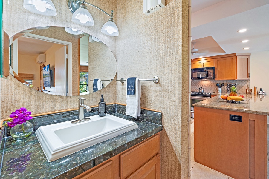 The bathroom at Kahana Sunset B4B features a stylish granite vanity, modern sink, and bright lighting for a comfortable start to your day.