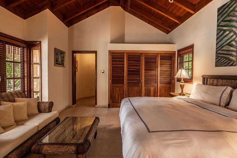 Elegant guest bedroom with wooden accents and comfortable seating.