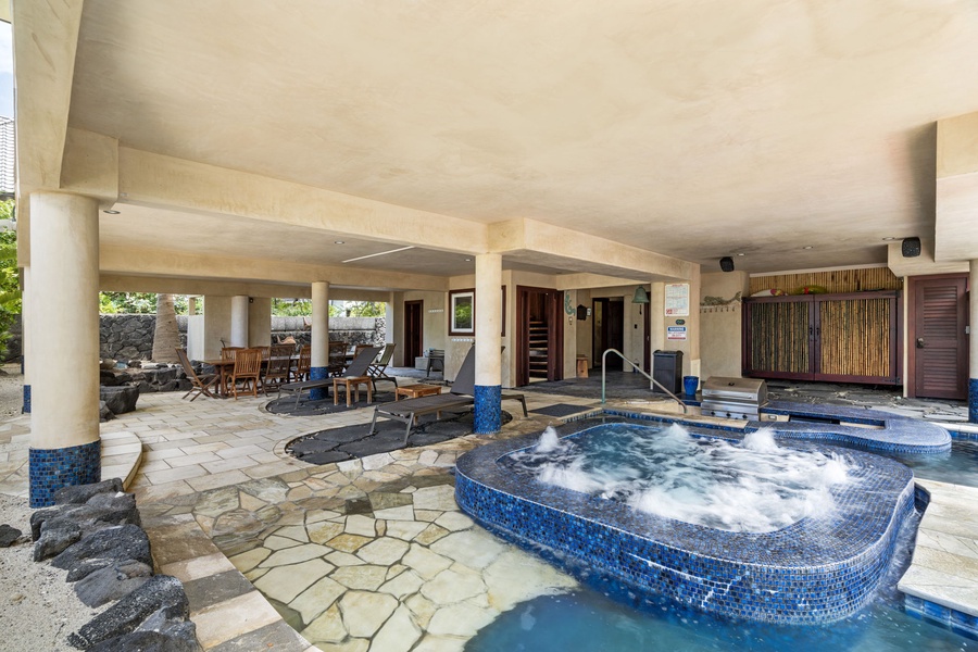 Covered spa area with loungers and tropical stone detail—perfect for shaded soaking year-round.