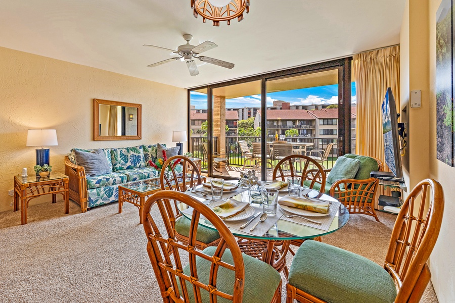 The dining area is set for a perfect meal with family or friends, offering easy access to the lanai for enjoying the beautiful outdoor views.