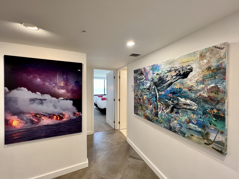 A bright hallway adorned with local artwork leads to the inviting bedroom.