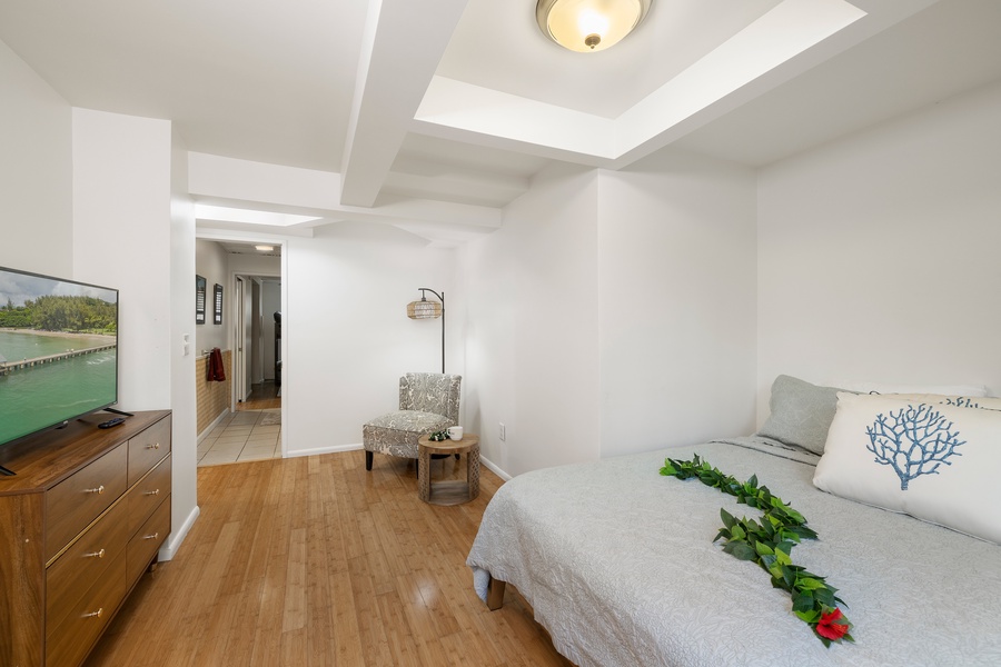 Simple and serene, this private guest suite features soft tones, a comfortable queen bed, and direct access to shared bath amenities.