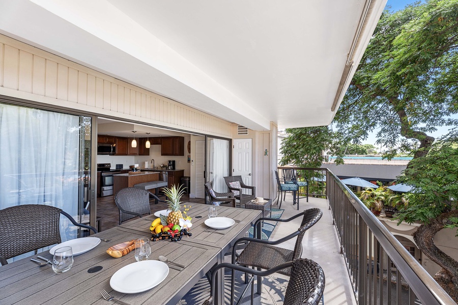 Outdoor lanai dining setup with a tropical backdrop, perfect for enjoying meals outside.