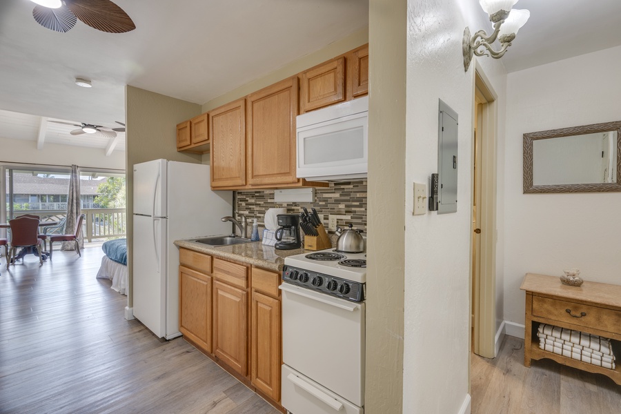 Your fully equipped kitchen features warm wood cabinetry, modern appliances, and stylish tile backsplash - perfect for preparing meals during your stay.