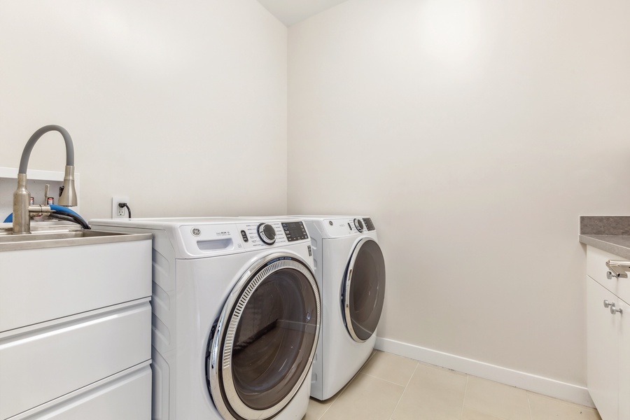 Laundry room equipped with a washer, dryer, and plenty of space for folding and storage.