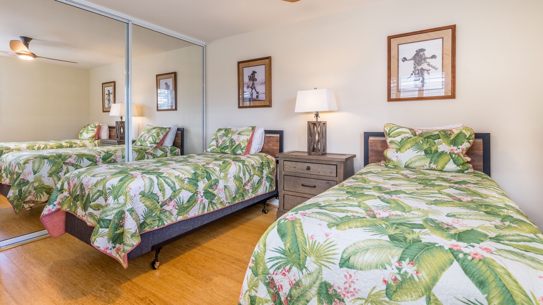 The guest bedroom featuring island prints and a desk area outside the room.