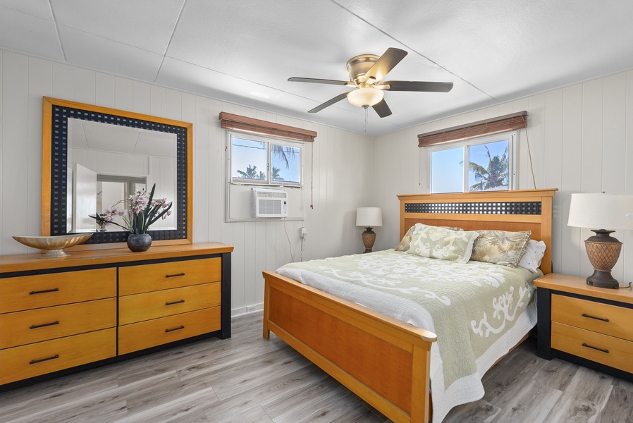 Peaceful guest suite with queen bed in the Ohana Island Retreat house, ceiling fan, and warm finishes.