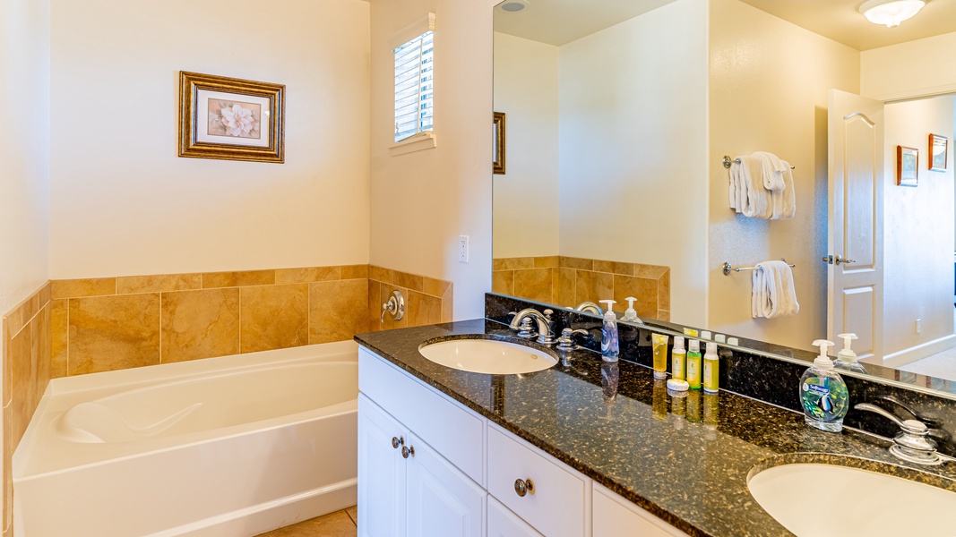 The primary guest bathroom with a soaking tub and large vanity.