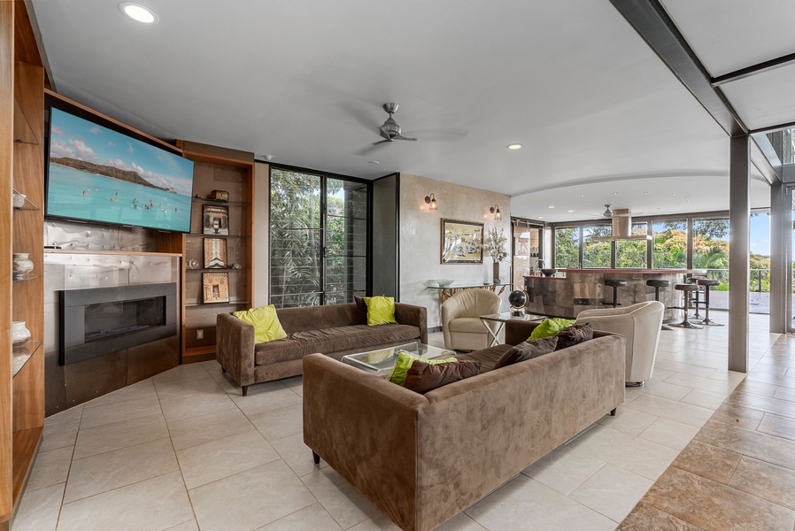 A cozy second living area with plush seating, natural light, and tropical views.