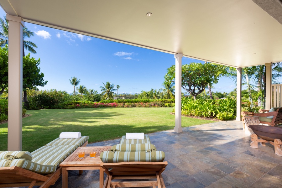 View of the expansive lawn from the lower lanai loungers.