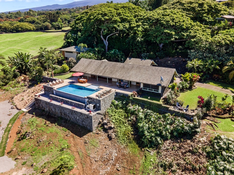 A stunning tropical property featuring a private pool surrounded by lush gardens and mountain views.