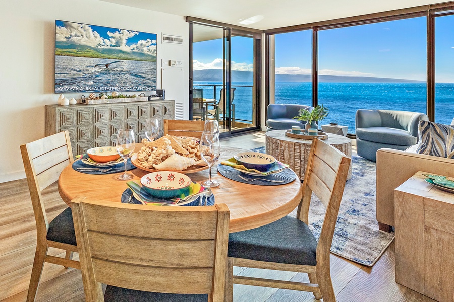 Enjoy ocean views while sharing meals at this inviting dining table, set in an open-concept living space with floor-to-ceiling windows that frame the beautiful sea.