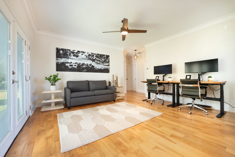 Spacious living area with a sofa, TV, and plenty of natural light.