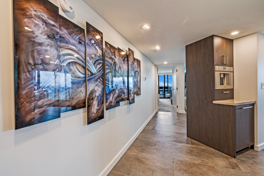 A stylish hallway with contemporary artwork leads you toward the stunning views awaiting in the living area.