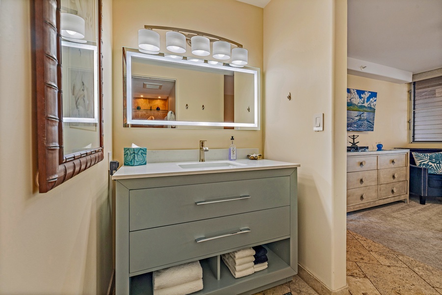The guest bathroom at Royal Kahana 610 offers a sleek, modern vanity with ample counter space and storage for your convenience.