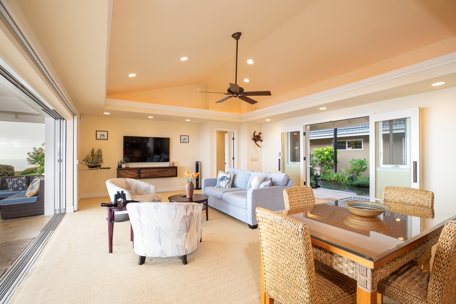 The main living space features large custom glass doors that open out to an expansive 70-foot lanai and truly allow for seamless indoor-outdoor living.