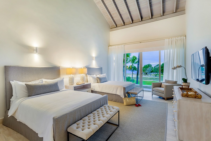The guest bedroom offers two queen beds and private patio.