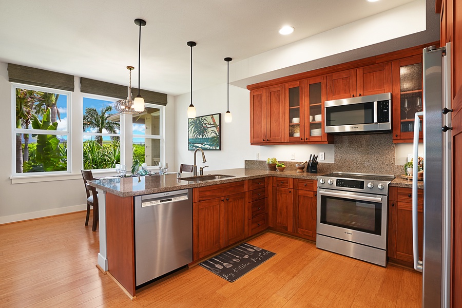 Open-concept living and dining space flowing into a kitchen with an island breakfast bar and quality stainless steel appliances.