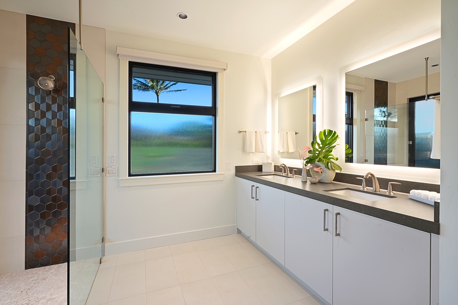 Contemporary bathroom with double vanity and a window framing serene views.