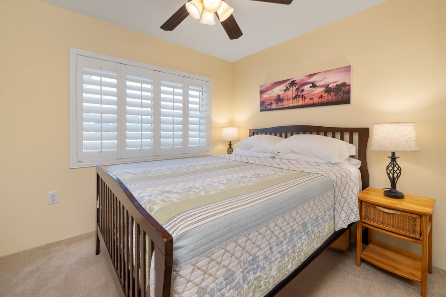 The third bedroom features a queen-size bed, soft lighting, and a ceiling fan for comfort.