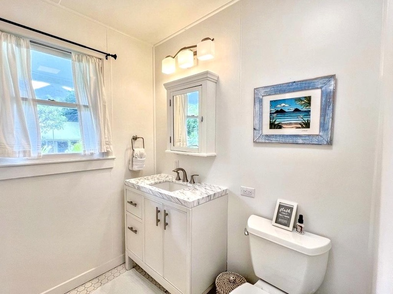 The shared bathroom in the main house is bright and functional, offering all the essentials.