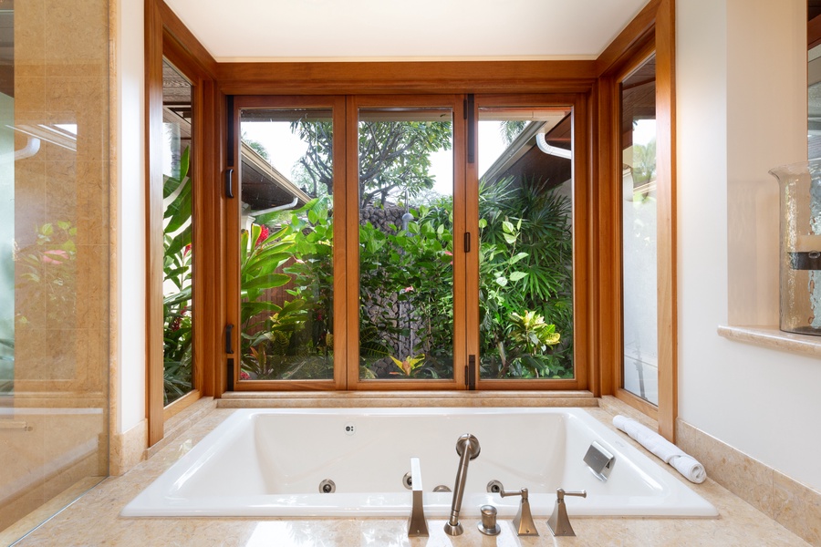 Oversized soaking tub with views of the tropical atrium