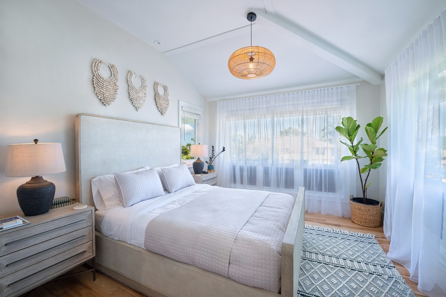 Bright and airy guest bedroom with a cozy queen-size bed, soft tones, and plenty of natural light.