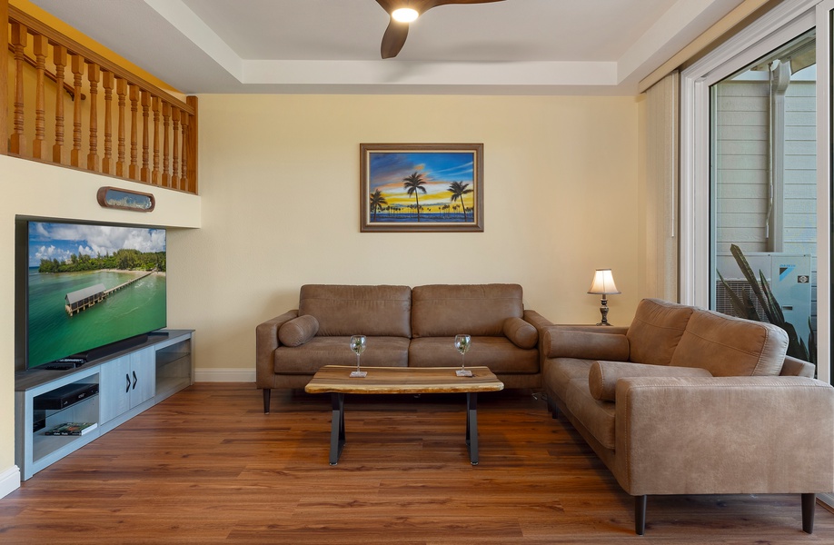 Relax in the cozy living room with plush seating and a large TV for entertainment.