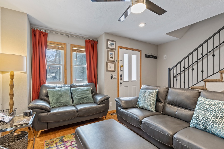Upon entering the condo, you'll immediately notice the beautiful hardwood flooring throughout the open-concept living area, furnished with comfortable sofas, a 55” flat-screen TV, and a gas fireplace that adds warmth and ambiance to the space