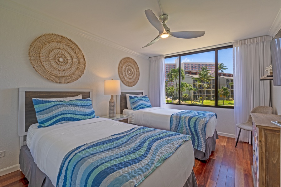 The guest bedroom features two cozy twin beds that can be converted to a a king-sized bed with colorful bedding and large windows