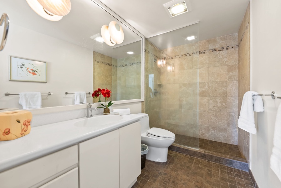 Modern bathroom with a glass-enclosed shower and sleek vanity, designed for comfort and convenience.