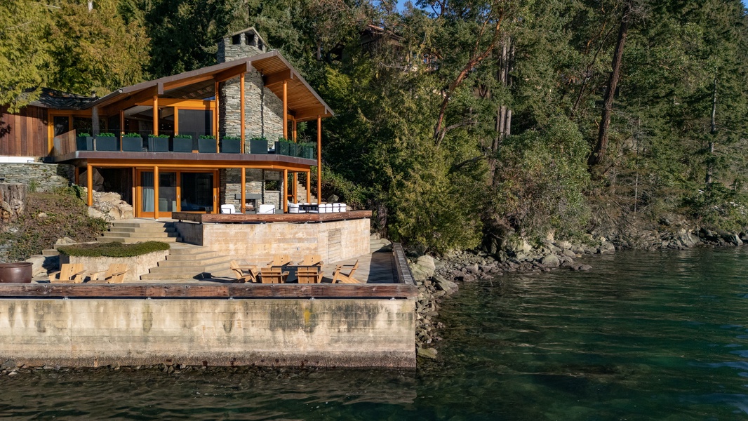 Modern waterfront retreat nestled among towering trees with private lakeside access and stunning natural surroundings.