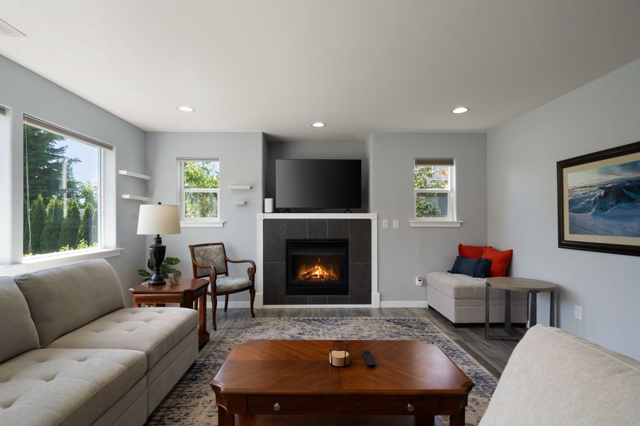 Gather around the fireplace after a day exploring Blaine, with plush seating and bright windows creating a warm, inviting atmosphere.