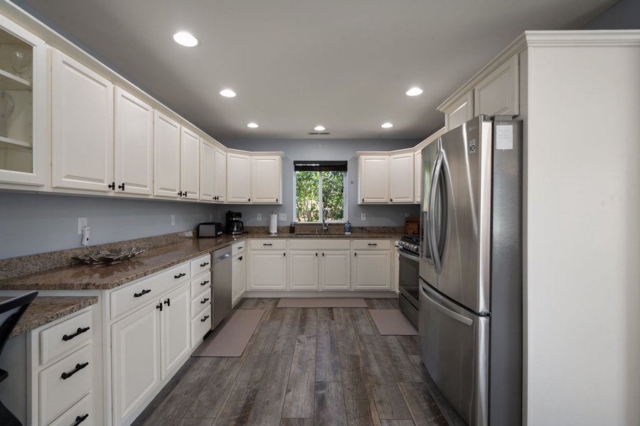 Prepare meals with ease in the fully stocked kitchen featuring modern appliances, extensive counter space, and generous cabinetry.