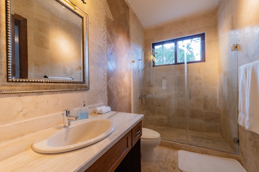 Ensuite bathroom with a spacious walk-in shower and elegant stone finishes.
