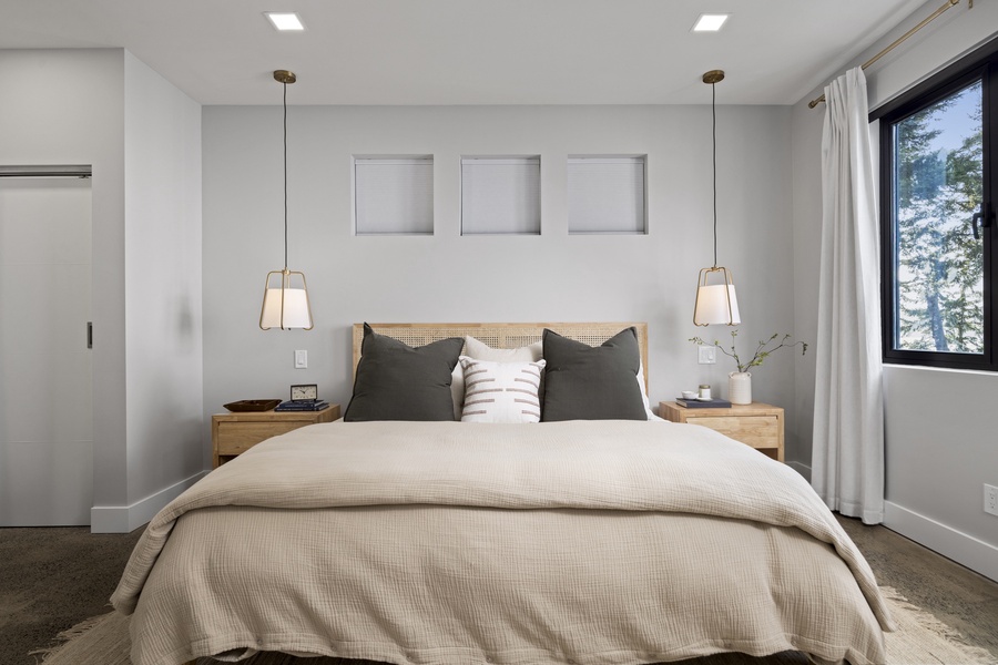 Elegant primary suite with king bed, modern lighting, and a serene palette designed for restful nights.