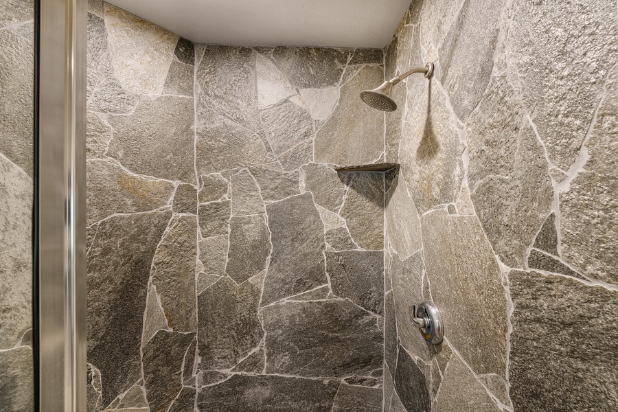 Detached guest bathroom with walk-in stone shower—resort-inspired design and convenience.