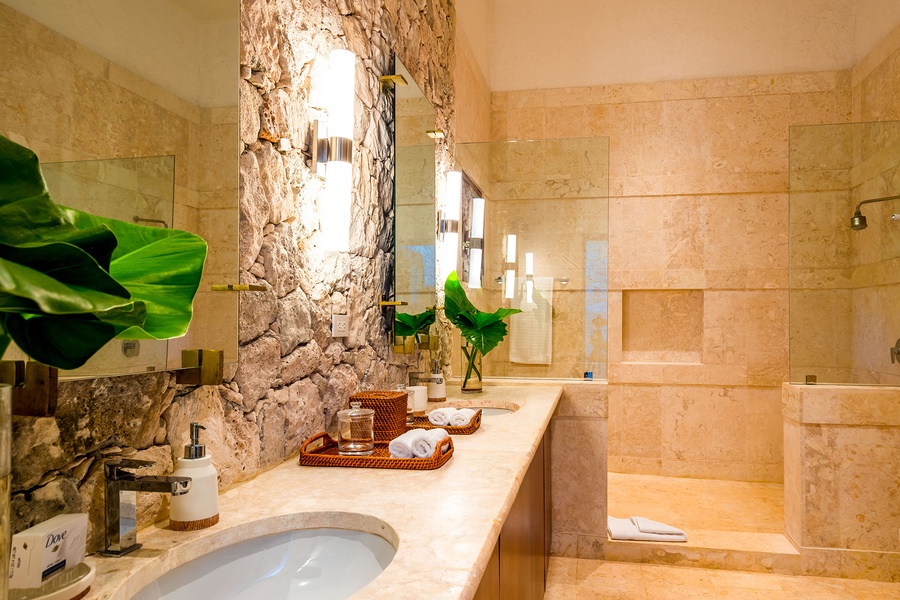 The full ensuite bathroom's interior with a stone accent wall.
