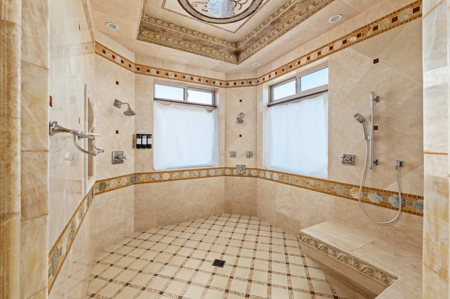 A showstopping walk-in shower wrapped in floor-to-ceiling tile brings a sense of calm and sophistication.