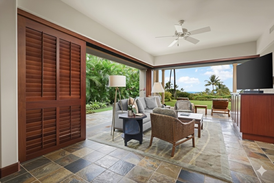 Retreat room with flat screen television, desk, plush seating and lanai.