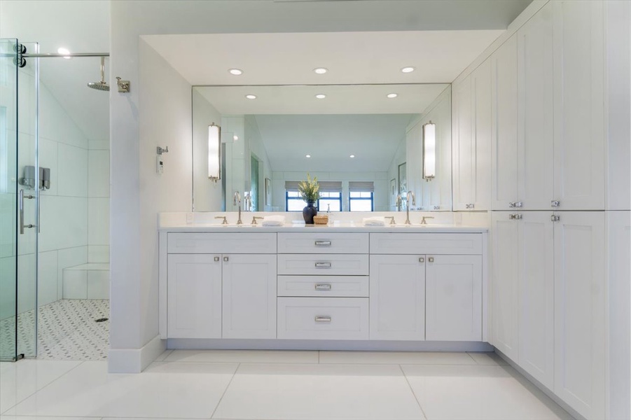 Bright double vanity space with ample storage and full-wall mirrors.