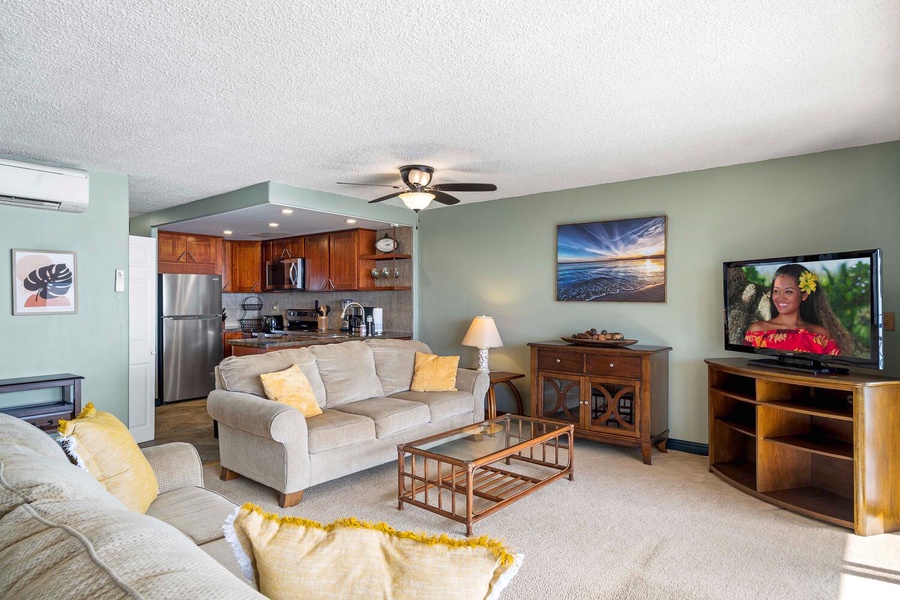 Living area with TV and cozy seating, adjacent to the kitchen and dining areas.