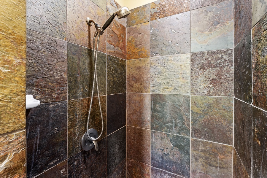 Rustic tiled walk-in shower with a rain-style showerhead for a refreshing retreat.