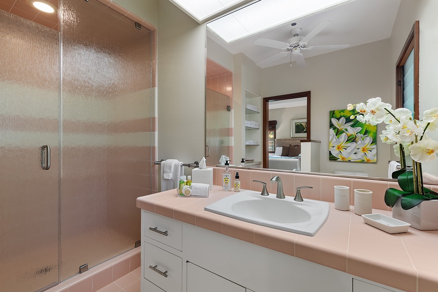 Beach house with modern amenities with a double vanity, large mirror, and spa-like finishes.