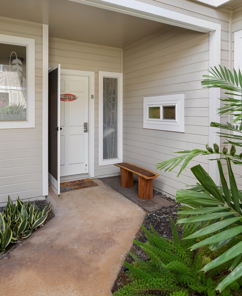 The welcoming front entrance is surrounded by lush tropical landscaping.