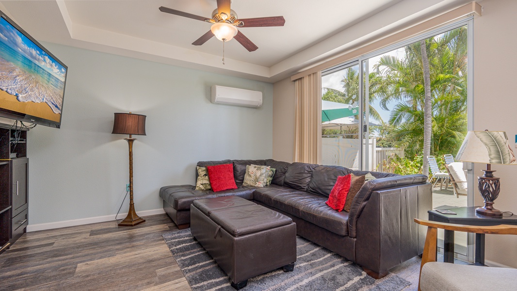 Relax in your spacious living room with plush leather seating, tropical garden views, and cool air conditioning after exploring.