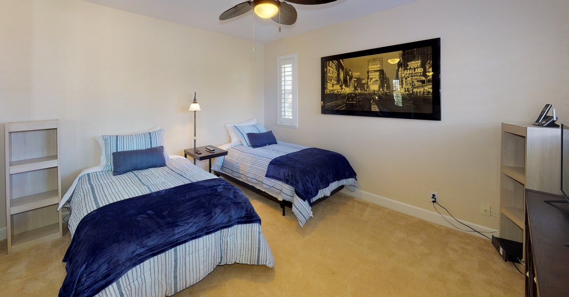 The third bedroom features twin beds and a TV.