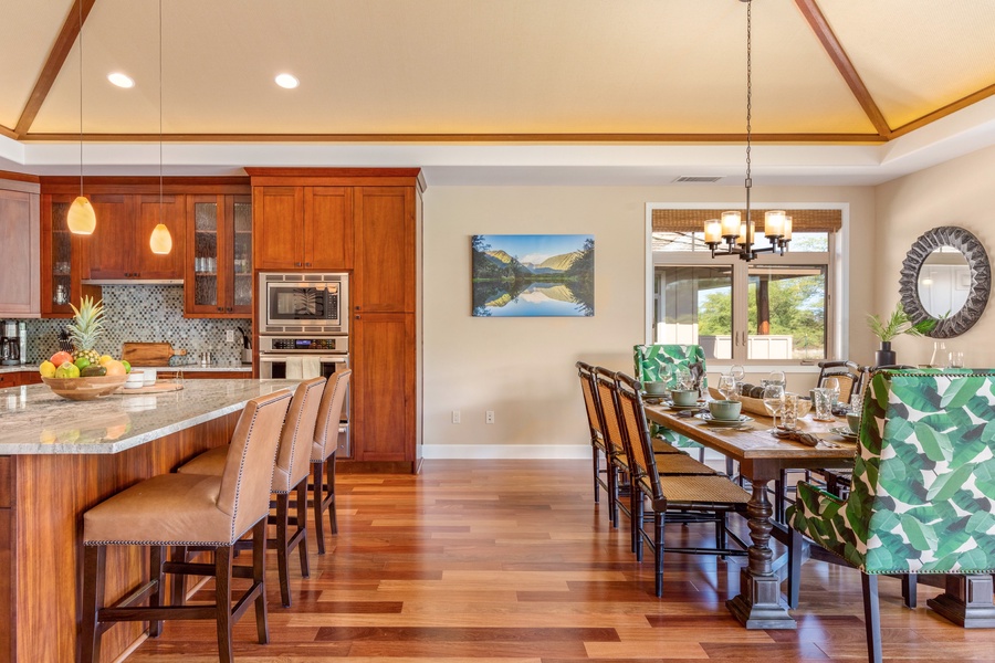 Breakfast bar and dining table for eight framed by soaring vaulted ceilings.